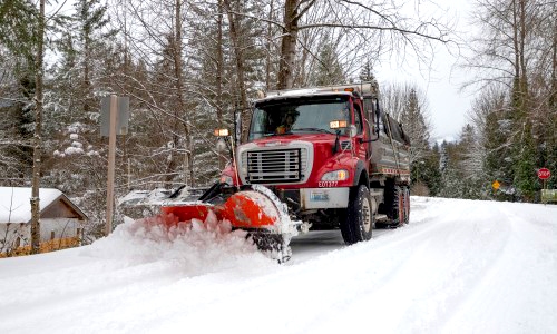 A snow plow plowing a road